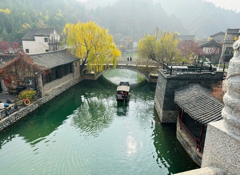A traditional boat on a narrow waterway, surrounded by historic buildings and a stone bridge. 4