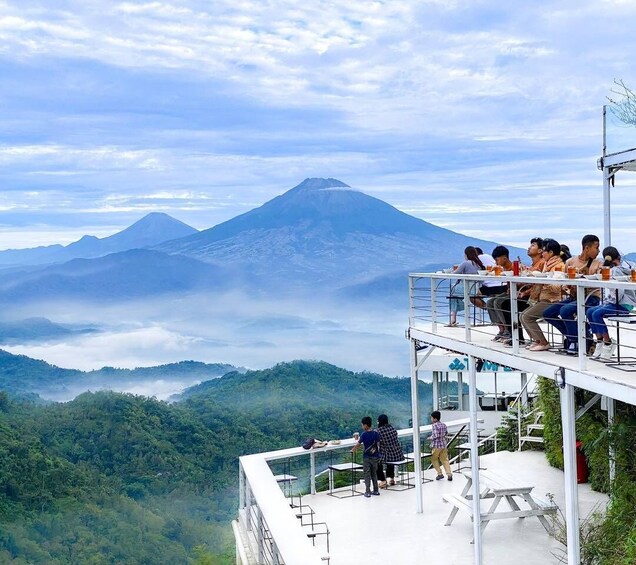 A group of people on a viewing platform overlooking a mountain range. 5