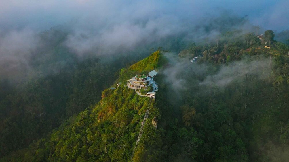 A mountain house surrounded by dense forest and mist. 2