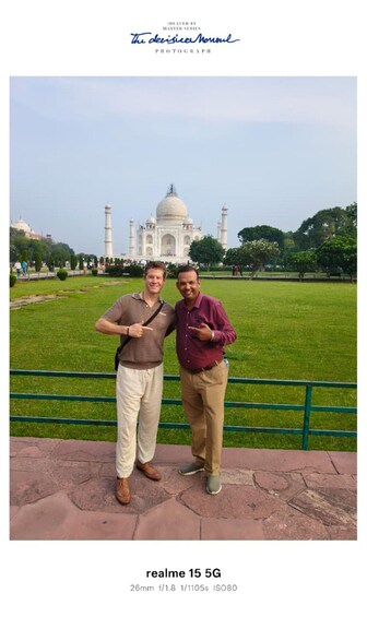 Two people standing in front of the Taj Mahal with a clear view of the monument. 2