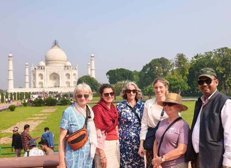 A group of people standing in front of the Taj Mahal. 1