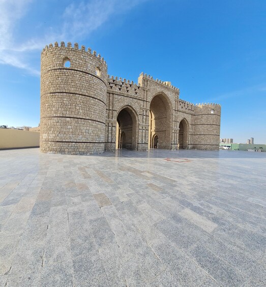 A large stone castle with arched gateways and crenellations. 1