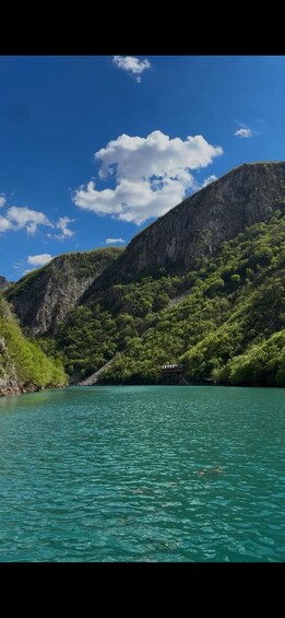 A mountain landscape with a clear blue sky and a turquoise lake. 5