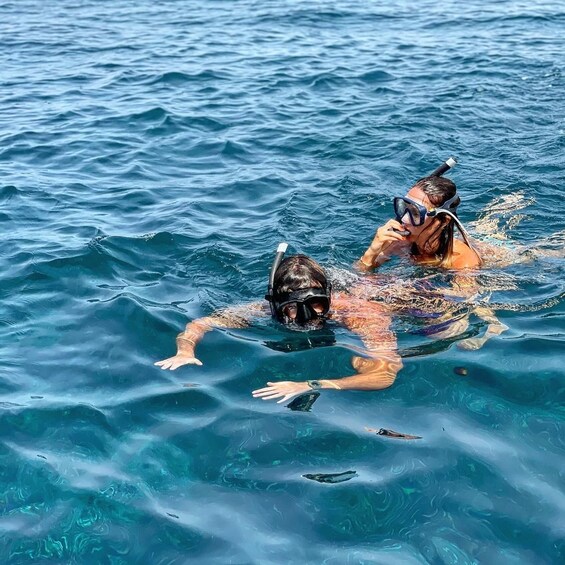 Two people snorkeling in clear blue water. 3