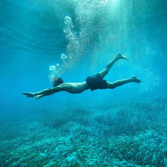 A person swimming underwater. 4