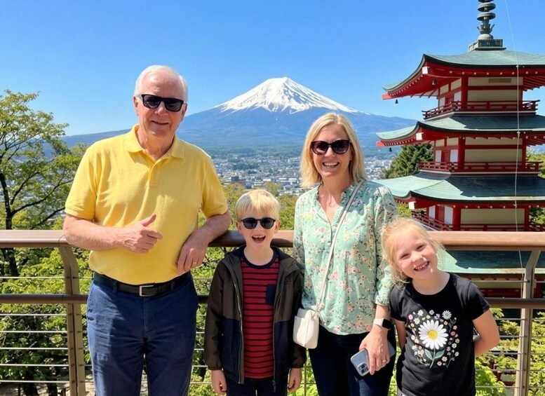 A family at a scenic overlook with a view of Mount Fuji and a traditional Japanese pagoda. 1