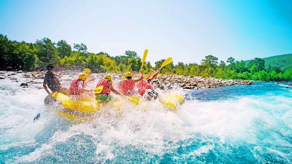 A group of people rafting on a river surrounded by greenery. 1