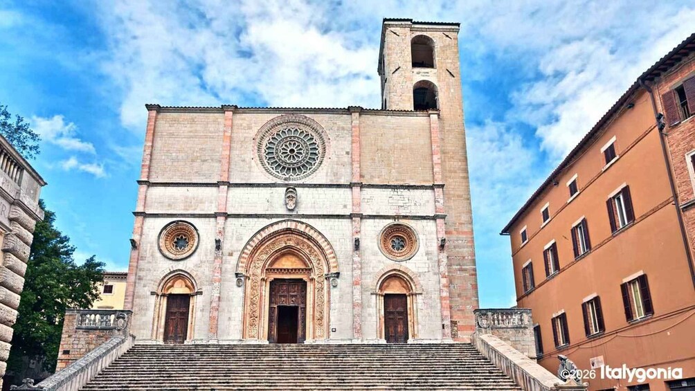 A historic church with a bell tower, arched doorways, and a circular window. 1