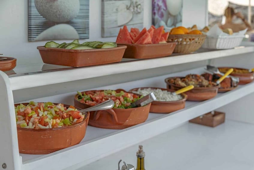 A buffet with various dishes including salads, fruits, and rice. 4