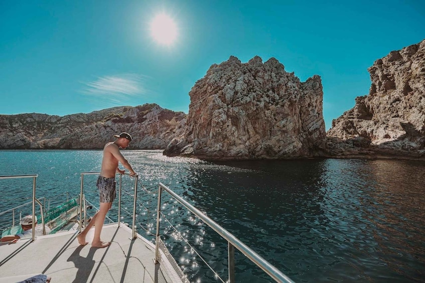 A person on a boat near rocky cliffs. 5