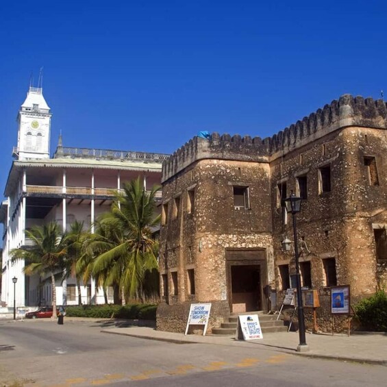 A historic building with a clock tower, palm trees, and a sign indicating a show tomorrow night. 5