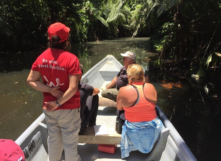 A group of people on a boat in a river surrounded by dense greenery. 4
