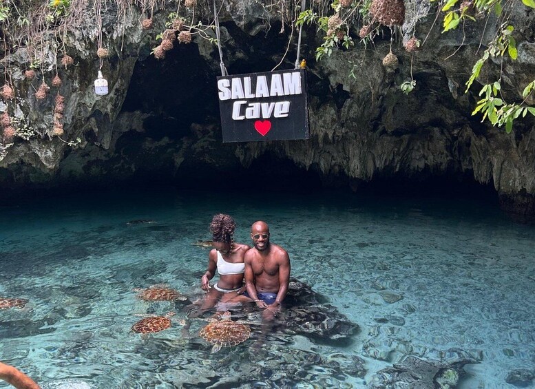 A couple in a cave with a sign reading 'SALAM Cave' and a heart symbol. 3