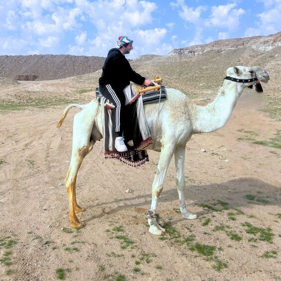 A person riding a camel in a desert landscape. 2
