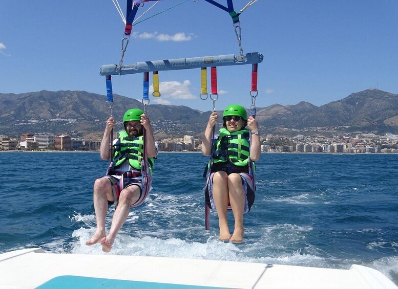 Two people on a boat, wearing life jackets and helmets, engaged in water sports. 3
