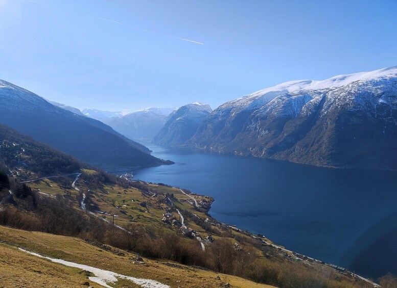 A fjord surrounded by snow-capped mountains and a small village. 5