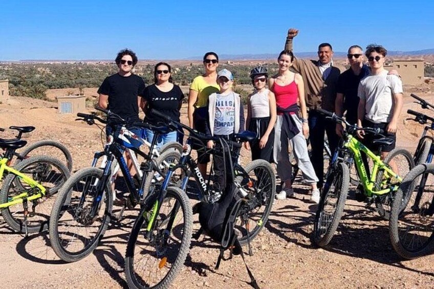 A group of people with bicycles in a desert landscape. 2