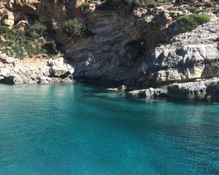 A coastal area with clear turquoise water and rocky cliffs. 4