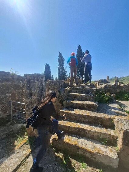 A person descending ancient stone steps, with another person ascending. 2