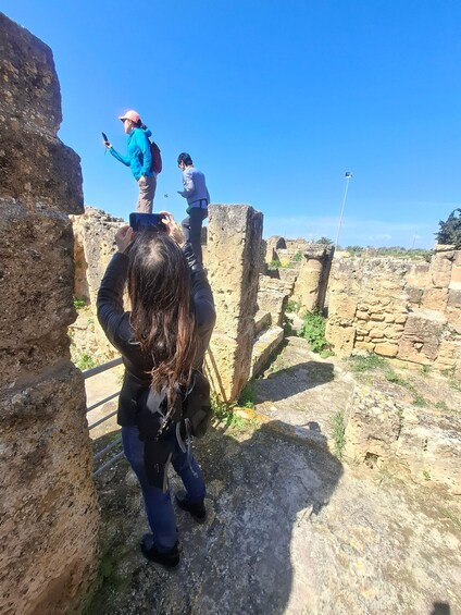 A person taking a photo of ancient ruins with a smartphone. 3