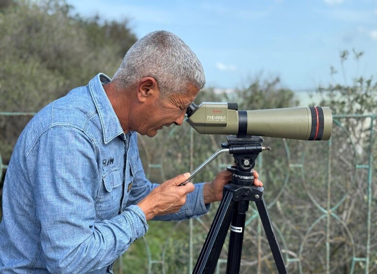 A person using a telescope on a tripod. 4