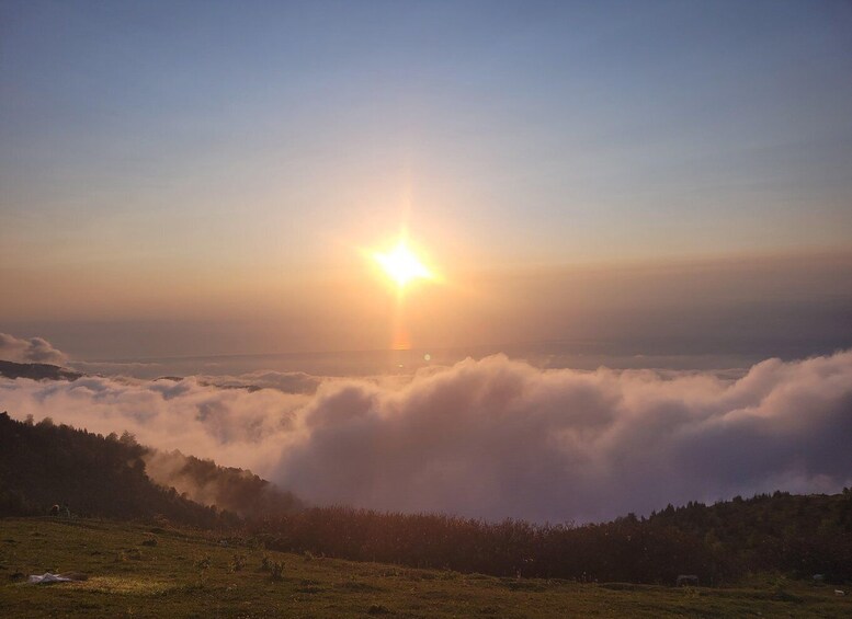 A sunrise over a valley with clouds below the horizon. 2