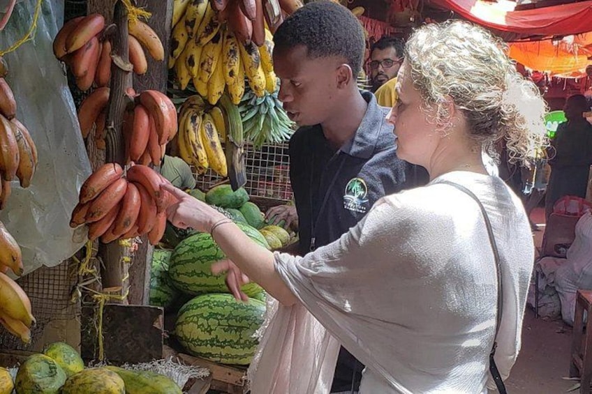 Un étal de marché où l’on vend des bananes, des pastèques et d’autres fruits. 2