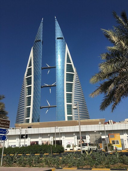 A modern building with two tall towers and wind turbines on top. 5