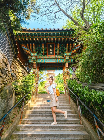 A person descending a stone staircase with a traditional Asian-style gate at the top. 3
