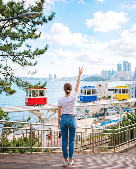A person standing on a bridge with a cityscape in the background. 2