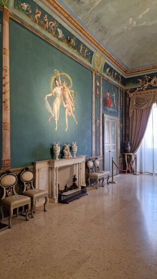 A grand room with classical frescoes, ornate columns, and classical statuary. 2