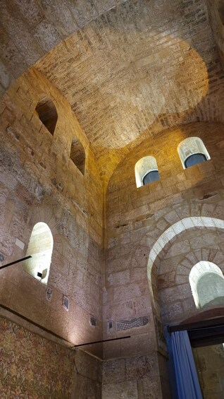 An interior with arched windows and stone walls. 4
