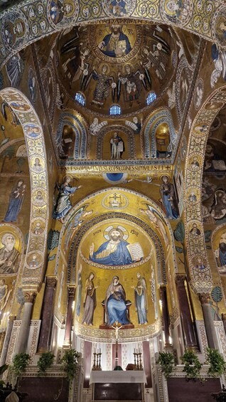 A richly decorated interior with golden mosaics, religious figures, and architectural columns. 5