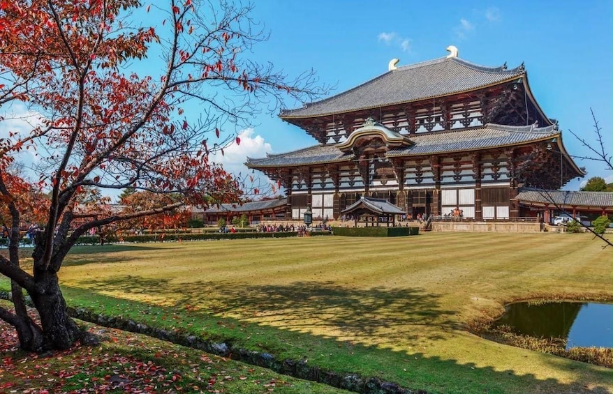 A traditional Japanese building with a large wooden structure and a pond in the foreground. 2