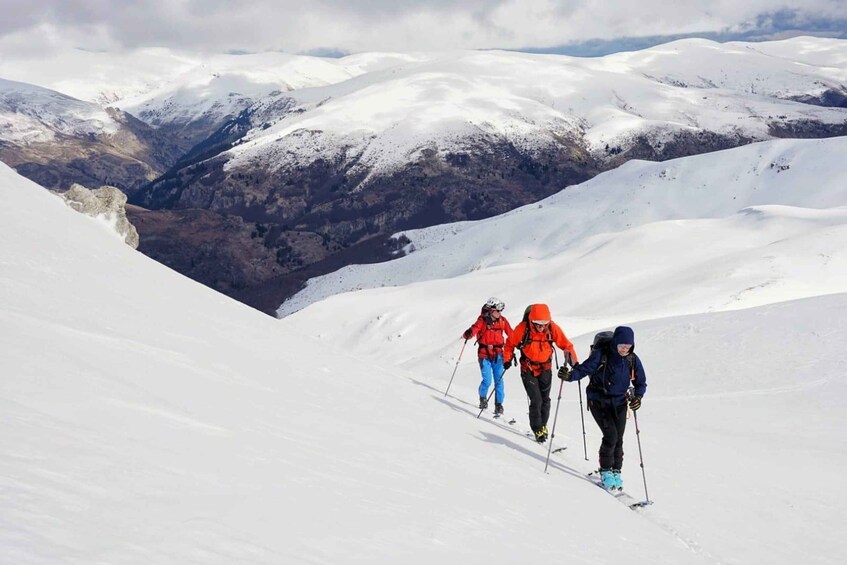 Three skiers ascending a snow-covered mountain slope. 1