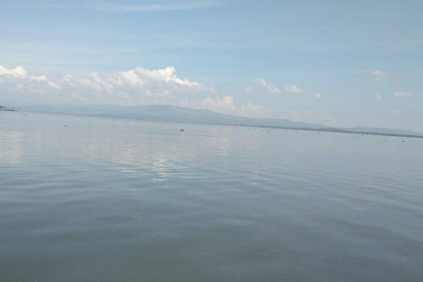 A calm body of water with a distant shoreline and a clear sky. 2