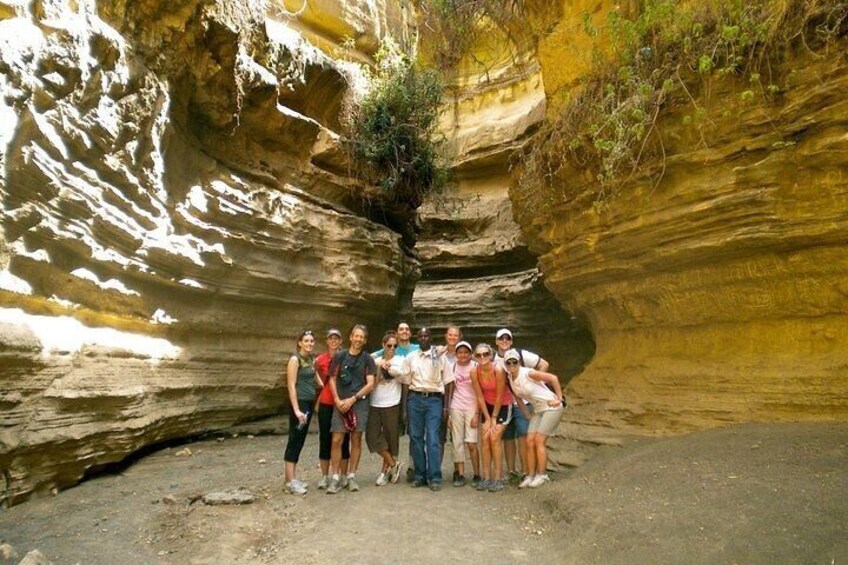 A group of people standing in a rocky canyon with layered rock formations. 3