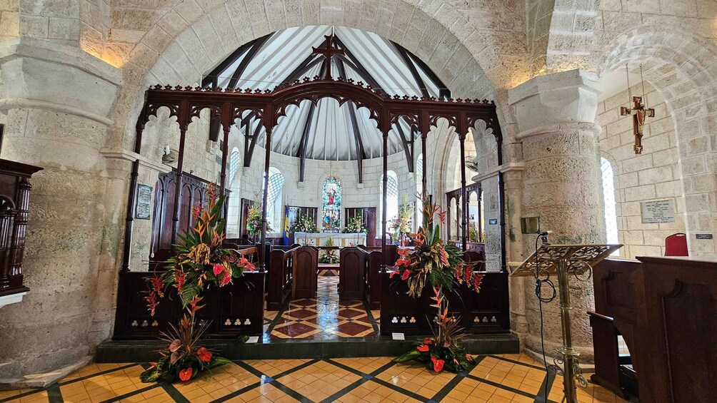 A church interior with an altar, pews, and floral decorations. 2