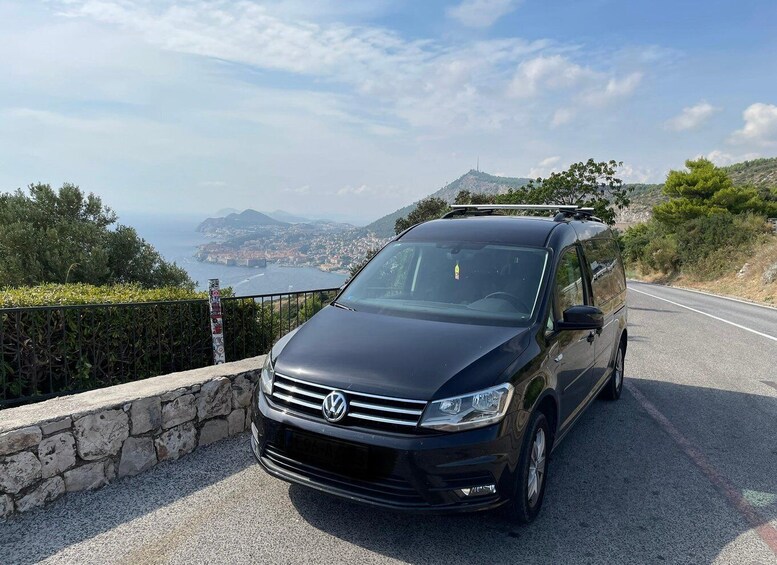 A black Volkswagen SUV parked on a winding road with a scenic coastal view in the background. 4