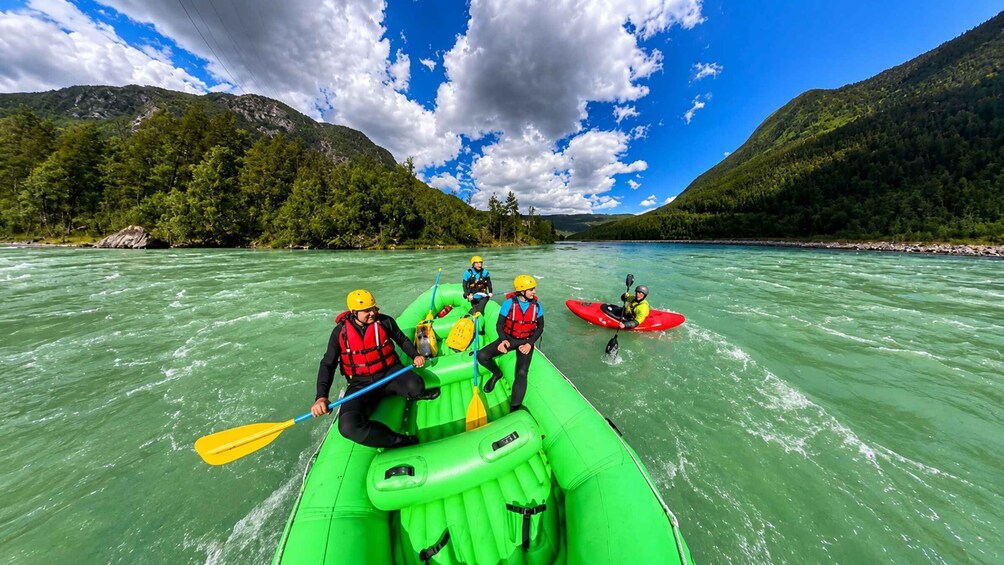A group of people kayaking on a river surrounded by lush green mountains. 2