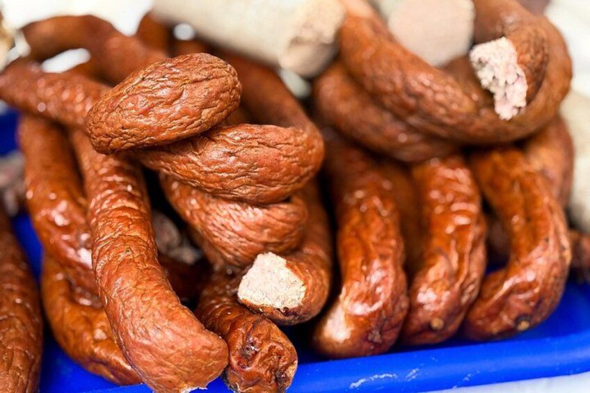 A pile of sausages with a blue background. 2