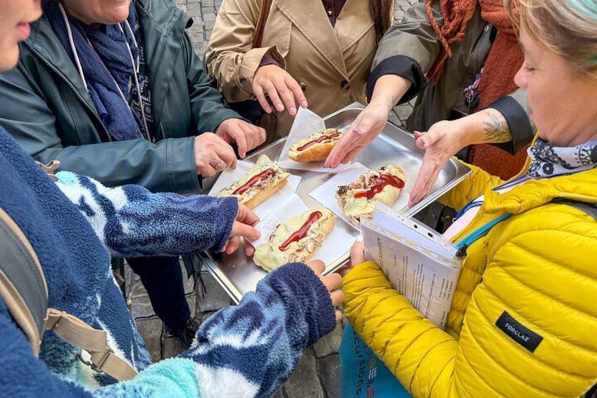 People sitting around a table with food, possibly enjoying a meal or snack. 1