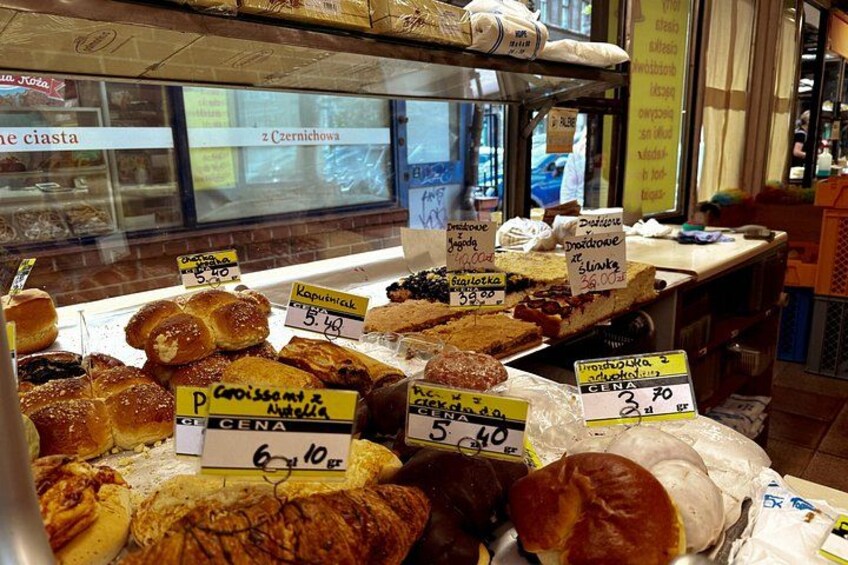 A bakery display with various baked goods and price tags. 5
