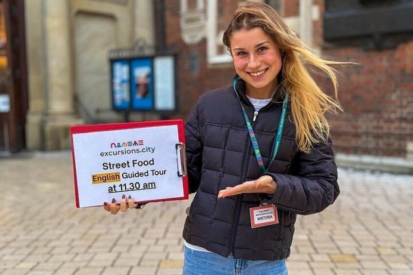 A person holding a sign for a street food tour. 2