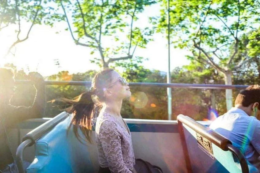 A person sitting on a bus, looking out the window. 5