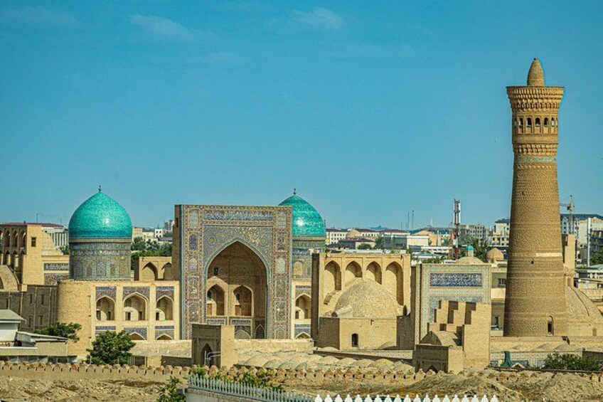 A historic building with domed roofs and a tall minaret. 2