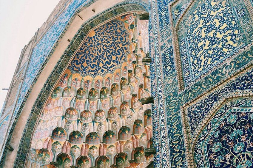 A detailed architectural facade with intricate tile work and arches. 1