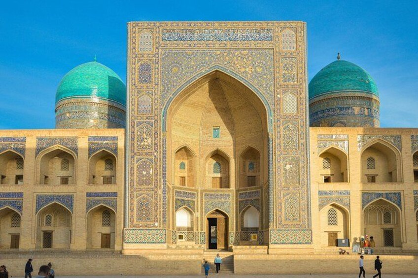 A historic building with intricate tile work and domed roofs. 5