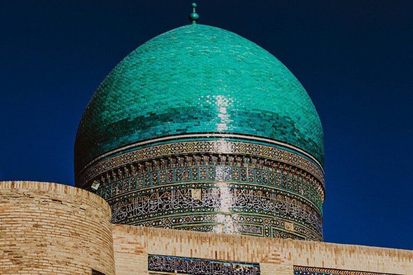 A large turquoise dome with intricate patterns and a wooden structure in the foreground. 4