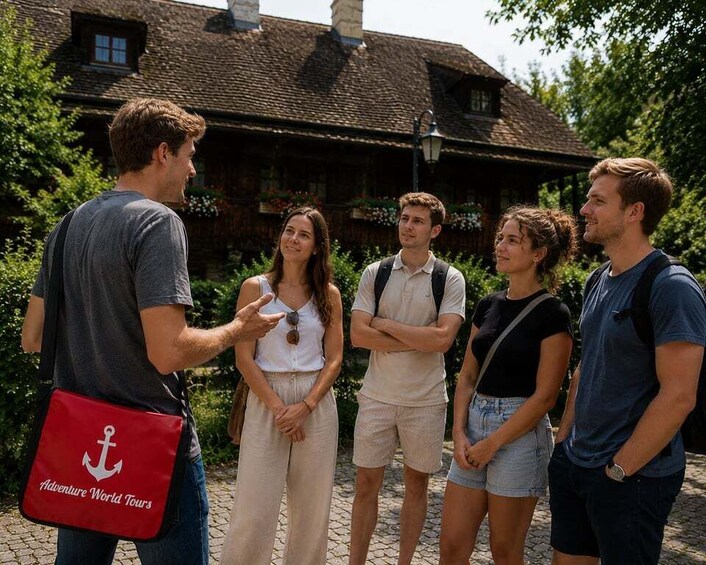 A group of people standing in front of a rustic building with a stone facade and a tiled roof. 5